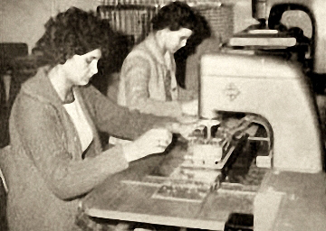 Foto: Buchbinderinnen arbeiten an Heftmaschinen