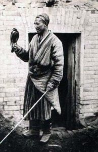 altes sw-Foto: Falkner in landestypischer Tracht mit Vogel auf der Hand