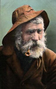 Fischerportrait mit Bart und Regenkleidung und Pfeife