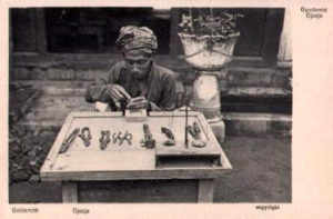 altes sw-Foto: Goldschmied am Tisch sitzend mit Werkzeugen