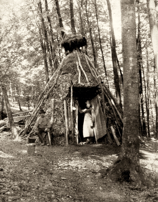 sw-Foto: Köhlerhütte mit Paar im Wald