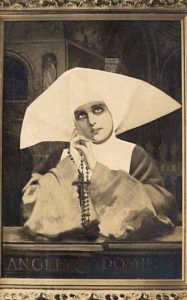 Nonne mit Haube mit Rosenkranz beim Beten