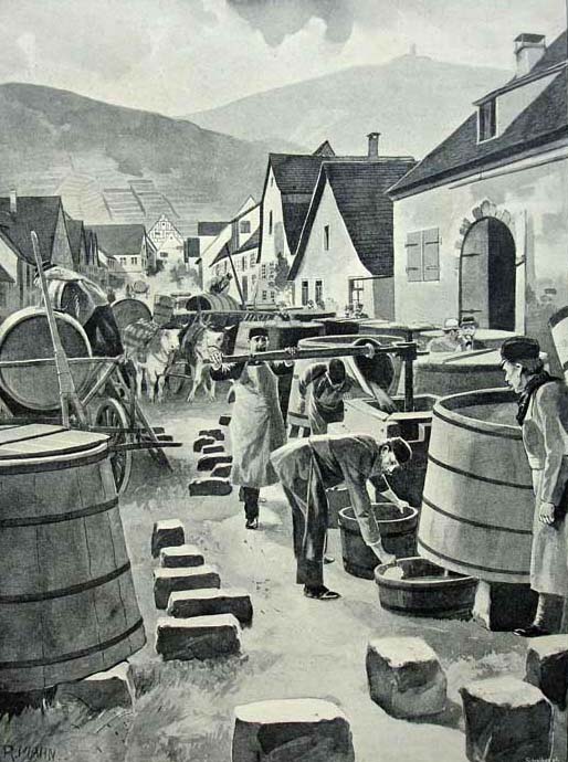Die Dorfkelterer haben große Weinfässen und Pressen auf der Straße aufgebaut