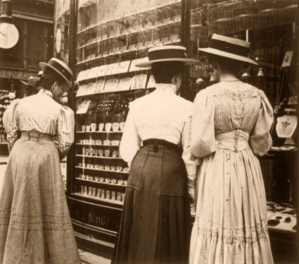 sw-Foto: drei Damen in langen Kleidern betrachten die Auslagen eines Juweliergeschäftes