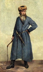 stehender Kosake in langem blauen Mantel, Fellmütze und Stiefel, Dolch am Gürtel und Pferdepeitsche in der Hand