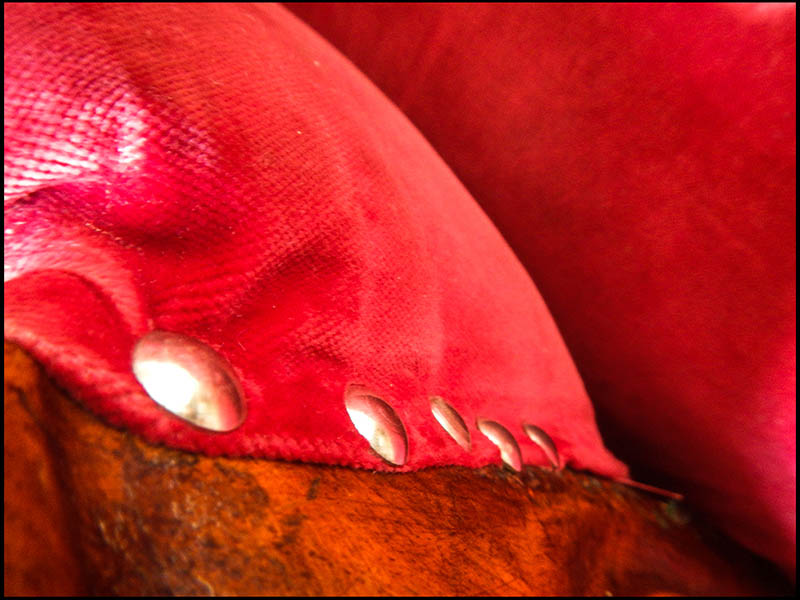 Farbfoto: Nahaufnahme: rotes Polster, Polsternägel