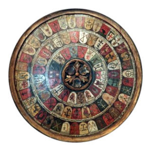 Farbfoto: runde Holztafel in drei runden aufgemalte Wappen zünftiger Schmiede