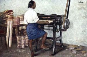 altes koloriertes Fotos: indischer Buchbinder steht mit einem Packen Papier an der Schneidemaschine