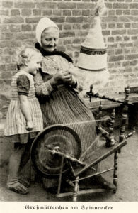 sw-Foto: Großmutter und Enkelin am Spinnrocken