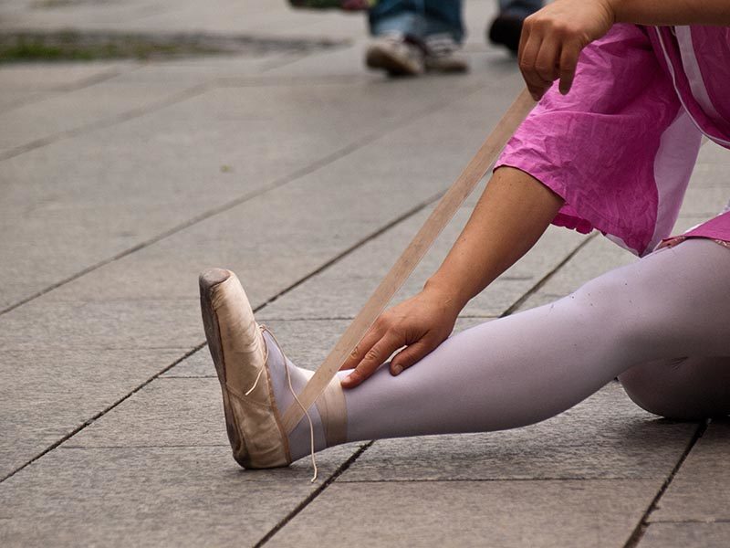 Farbfoto: Frau wickelt ihren Ballettschuh