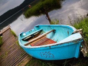 Farbfoto: blauer alter Kahn liegt am Bootssteg am See