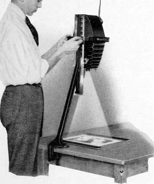 altes sw-Foto: Mann steht am Vergrößerungsgerät