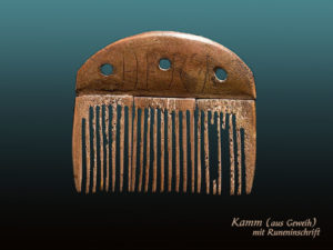 Farbfoto: antiker, aus Geweih geschnitzter Kamm mit Runeninschrift