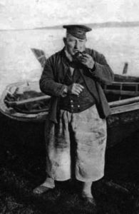 sw-Foto: Fischer mit Pfeife vor seinem Boot stehend