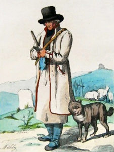 Schäfer in weißem Mantel mit seinem Hütehund