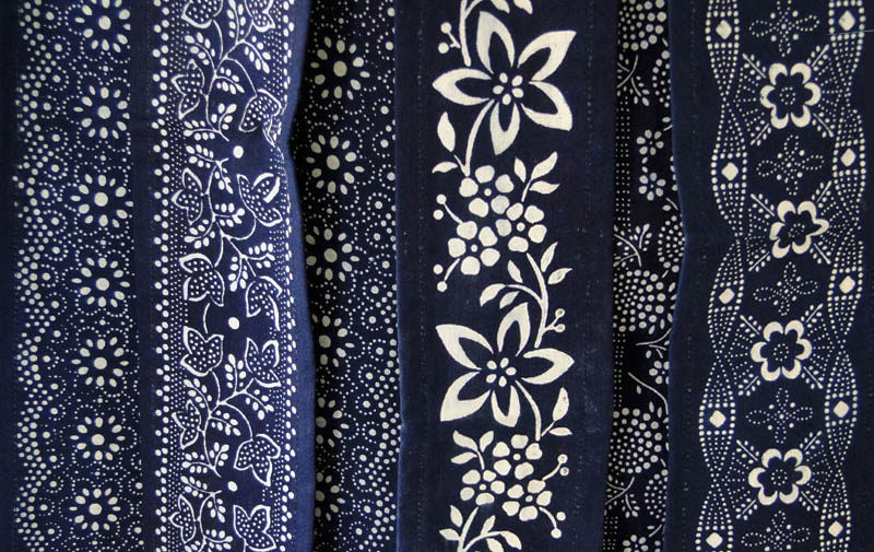 Farbfoto: mehrere Stoffbahnen mit Blaudruck verschiedener ornamentaler Muster