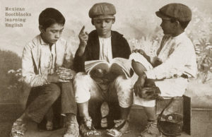 s/w Foto: drei Schuhputzjungen bringen sich selber die Englisch bei