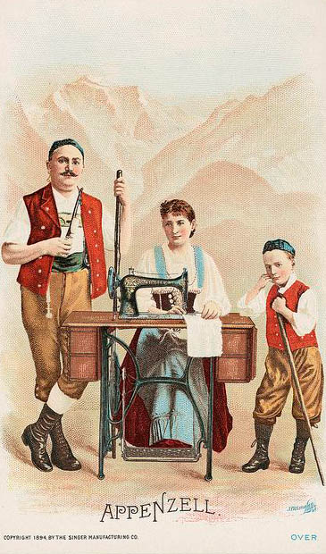 alte Postkarte: Frau sitzt an Nähmaschine und näht, Mann und Junge stehen daneben, im Hintergrund Berge