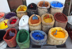 Farbfoto: offene Säcke mit verschiedensten Farbpulvern und Schäufelchen sowie rechts eine Waage