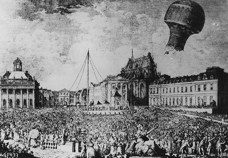 sw-Zeichnung: Die Brüder Montgolfier lassen einen Ballon aufsteigen, eine große Menschenmasse befindet sich auf dem Platz