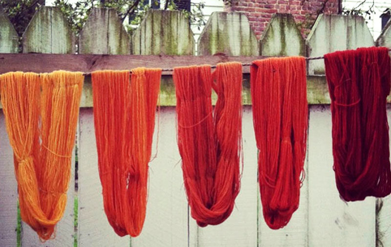 Farbfoto: Wolle in verschiedenen Rottönen zum Trocknen auf der Leine