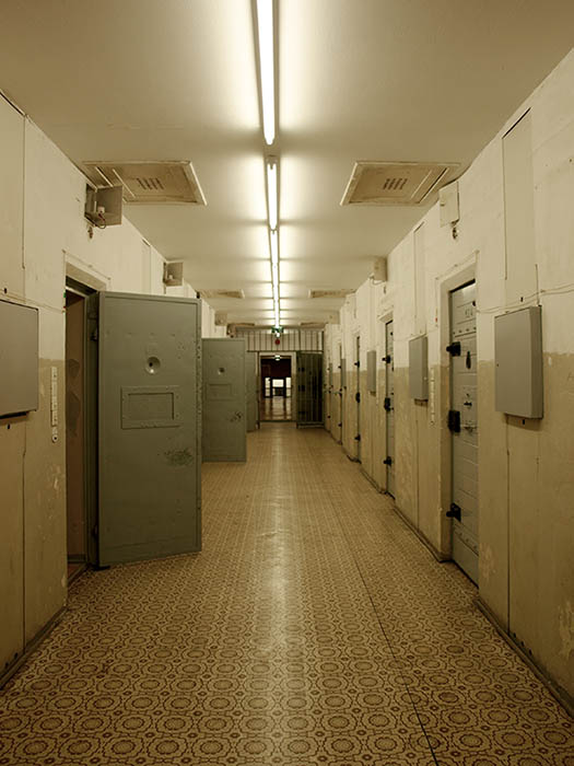 Farbfoto: Blick in den Gefängnistrakt; einige Türen stehen offen
