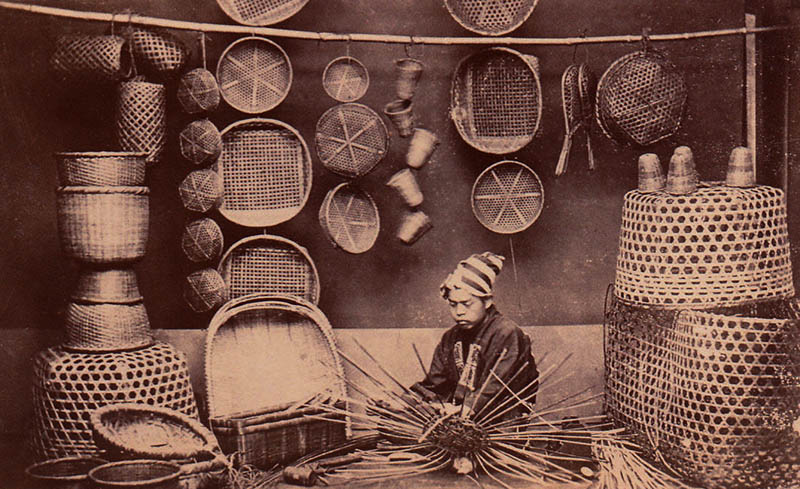 Foto: japanischer Korbmacher sitzt zwischen seinen Körben