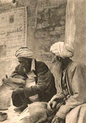 sw Foto: zwei alte Straßenschuster mit Turban vor Mauer am Boden sitzend