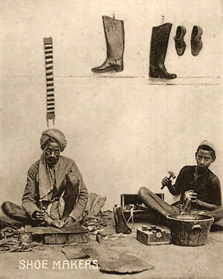 sw Foto: ein älterer und ein jüngerer Schuster arbeiten am Boden sitzend - 1920