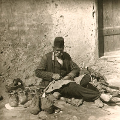 sw Foto: alter Schuster sitzt arbeitend am Boden vorm Haus - Türkei, 1930