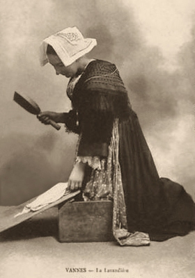 sw Foto: Waschfrau in bretonischer Tracht mit Wäscheklopfer