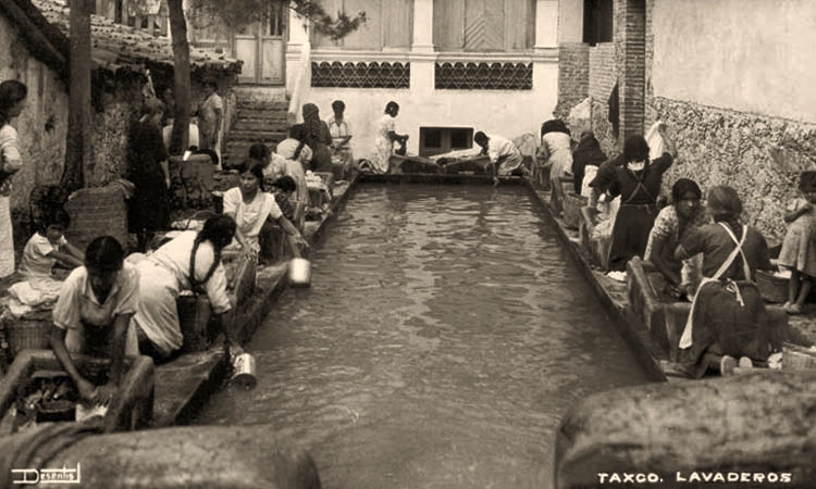 sw Foto: Frauen rund um ein Wasserbecken waschen kniend an steinernen Podesten mit Wassermulden