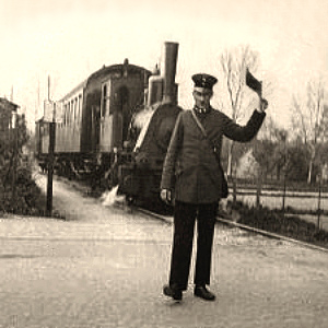 sw Foto: Bahnwart regelt mit Signalflagge Vorfahrt für einen Zug