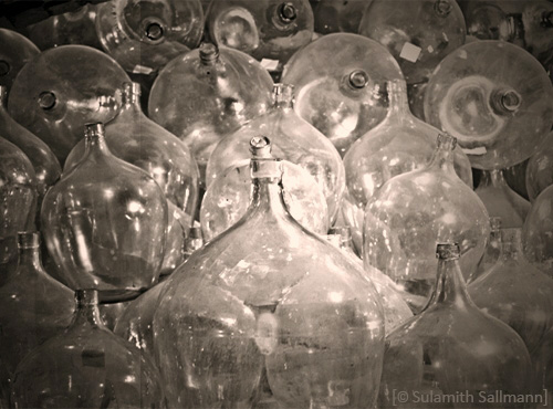 sw Foto: viele zusammen gestapelte Ballonflaschen aus Glas