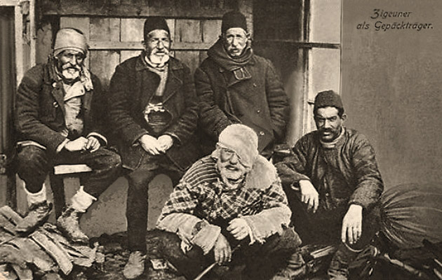 sw Postkarte: Gruppenfoto von fünf bei Gepäck sitzenden Trägern