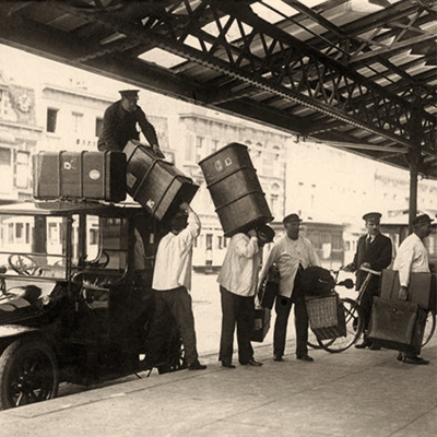 sw Foto: Träger bringen Gepäck vom Auto zum Zug