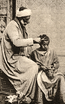 sw Postkarte: Mann mit Turban schneidet einem Junge die Haare - 1900, Orient