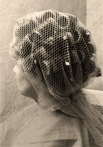 Farbfoto: Frau im Friseursalon mit Haarnetz