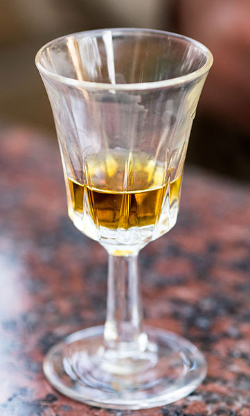 Farbfoto: Trinkglas mit einem Schlückchen Propolisschnaps