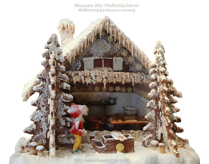 Farbfoto: offenes Pfefferkuchenhaus mit Blick in Miniaturbackstube