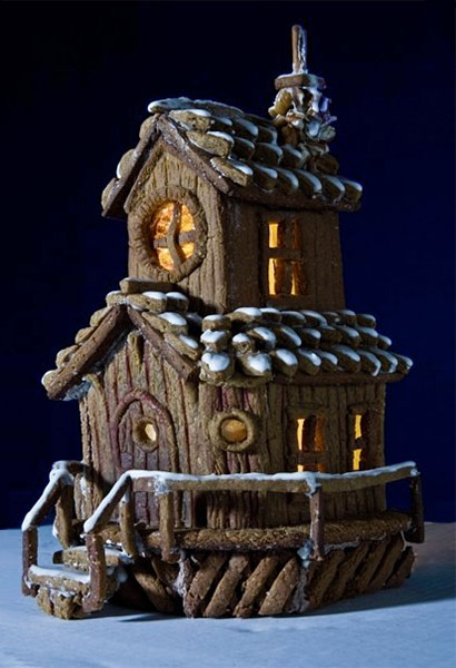 Farbfoto: rustikales zweistöckiges Lebkuchenhaus mit Zuckerguß-Schnee