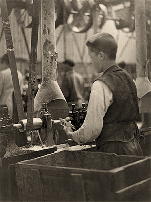 sw Foto: junger Knopfmacher arbeitet an einer Maschine