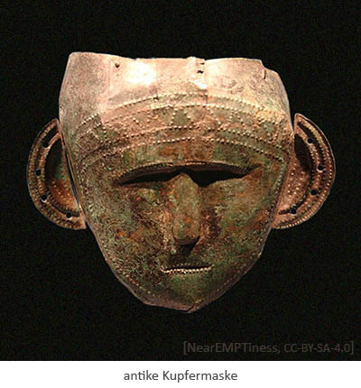 Farbfoto: antike Maske aus Kupferblech