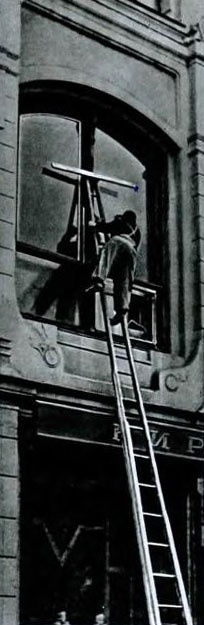 sw-Foto: Fensterputzer auf sehr hoher Leiter beim putzen einer Scheibe