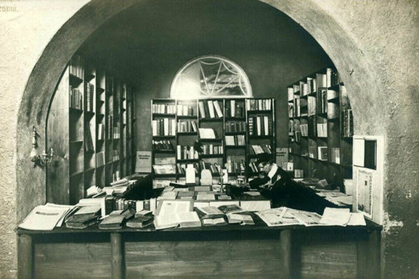 Foto: Buchhändler sieht in einem Gewölbe zwischen Büchern
