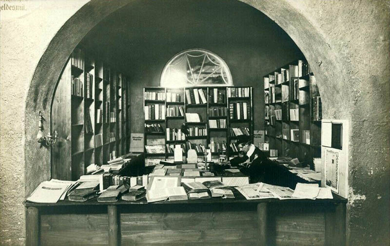 Foto: Buchhändler sieht in einem Gewölbe zwischen Büchern