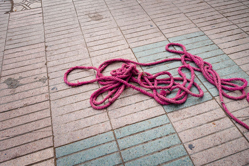 Foto: himbeerfarbenes Seil auf Boden liegend