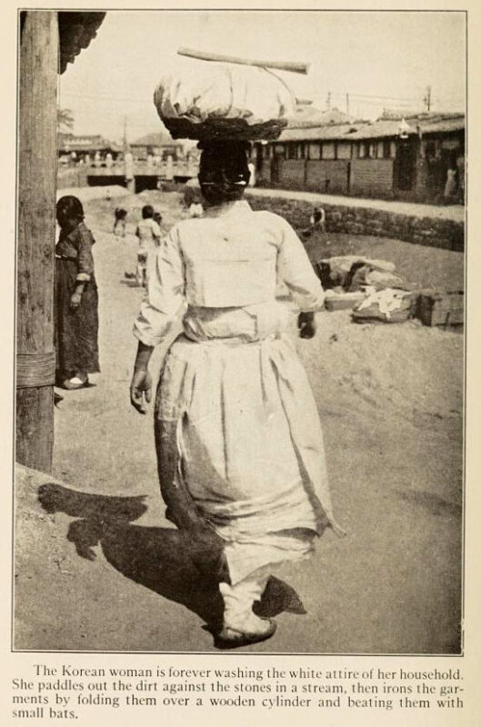 Frau trägt Wäscheballen auf ihrem Kopf