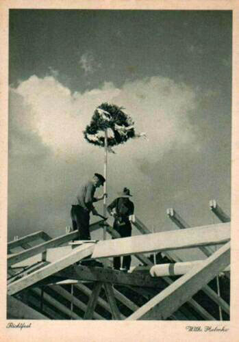 Fotokarte: zwei Männer setzen Baum auf neues Dachgerüst